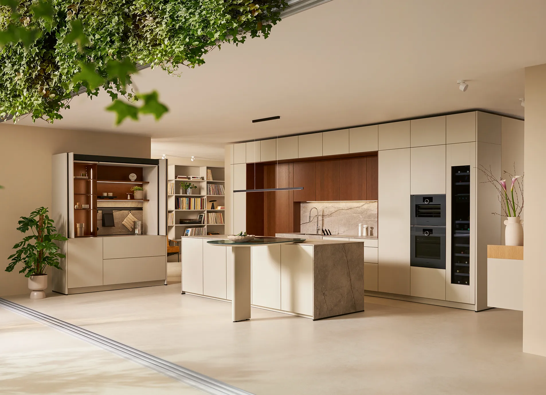 Großzügige next125 Küche mit Insel, Naturstein und Nussbaum im Showroom